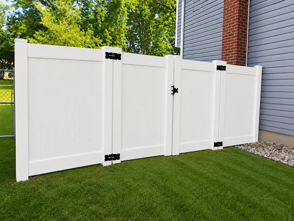 White Country Estate vinyl privacy fence with matching gate installed beside a home in Davison, Michigan.