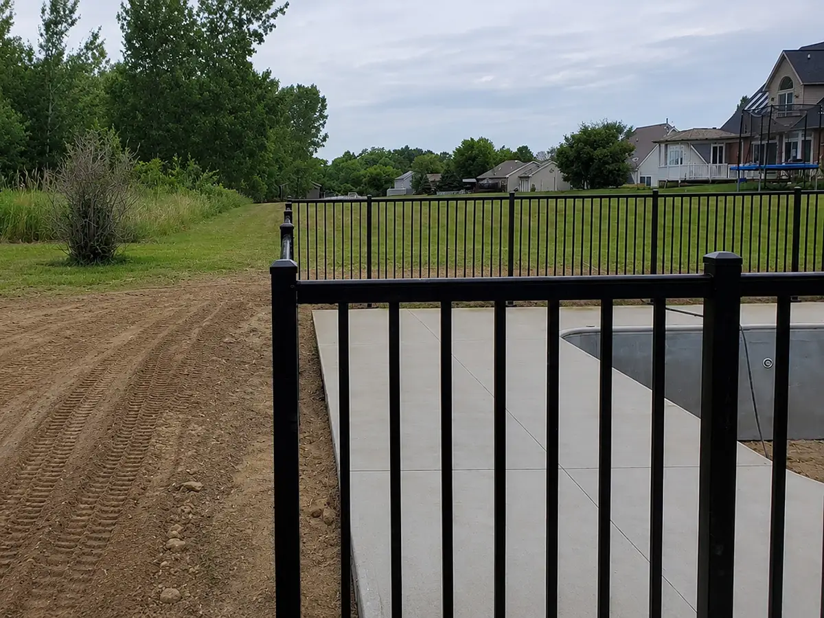Black aluminum fence installed around a residential swimming pool in Fenton Township, Michigan.