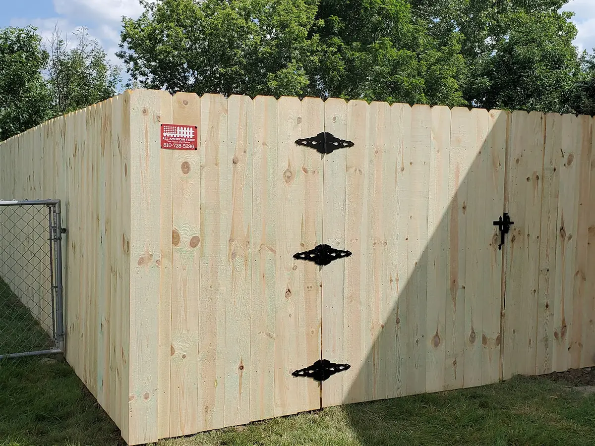 Wood privacy fence with a 4-foot walk gate installed at a residential property in Flint, Michigan.